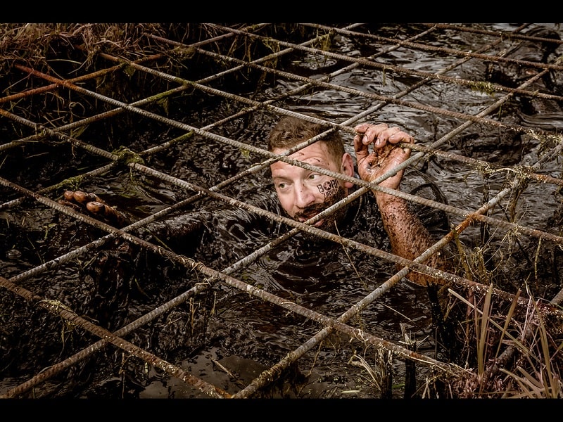 A man swimming through mud.